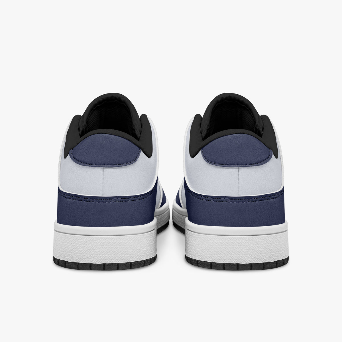 Rear view of navy blue and white sneakers showing dark navy heel overlays, white leather collars, and black interior collar lining above white midsoles.