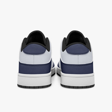 Rear view of navy blue and white sneakers showing dark navy heel overlays, white leather collars, and black interior collar lining above white midsoles.