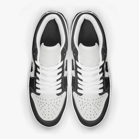 Overhead view of black and white sneakers showing clean white laces, white padded collar lining, and perforated white leather toe boxes.