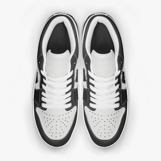 Overhead view of black and white sneakers showing clean white laces, white padded collar lining, and perforated white leather toe boxes.