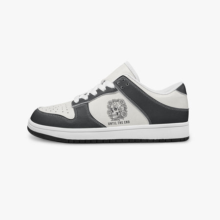 Side profile view of the left sneaker in black and white leather, highlighting the "UNTIL THE END" skull graphic, white laces, white interior lining, and flat rubber sole facing right.