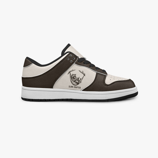 Side profile view of the right sneaker showcasing the dark brown and cream color blocking, raccoon emblem, black laces, and dark rubber outsole facing right.