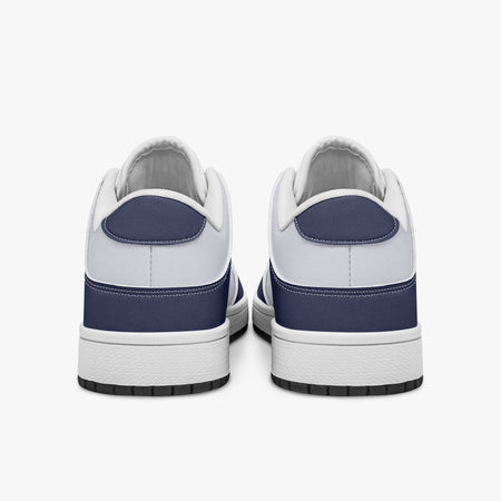Rear view of navy blue and white sneakers displaying dark navy heel overlays, white leather collar panels, and two-tone white and black rubber outsoles.