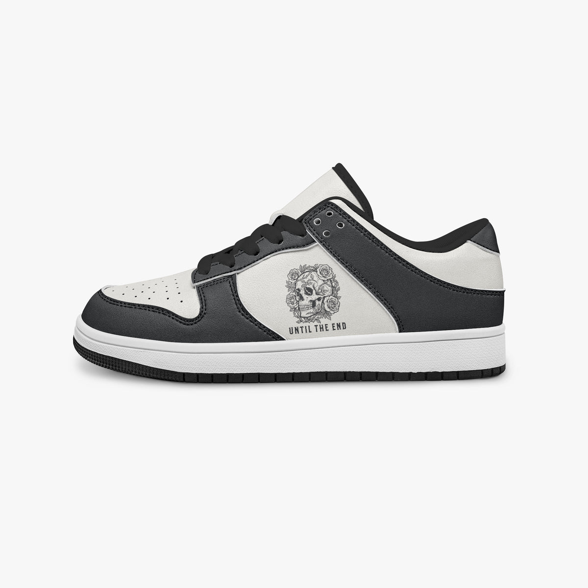 Side profile view of the left sneaker highlighting the black leather panels, floral skull emblem, black interior lining, and flat rubber sole facing right.