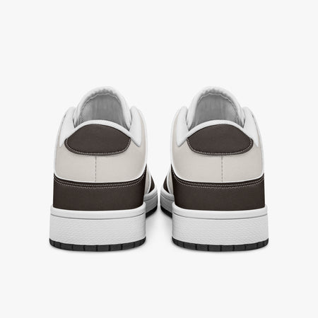 Rear view of brown and cream sneakers displaying espresso brown heel overlays, off-white leather collar panels, and two-tone white and black rubber outsoles.