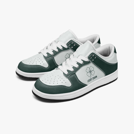 Angled three-quarter view of low-top sneakers in dark emerald green and white leather, featuring a four-leaf clover graphic with "LUCKY CHARM", white laces, and a white inner lining.
