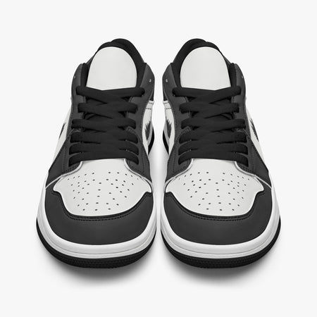 Front-facing eye-level view of black and white low-top sneakers showcasing black laces, black tongue trim, and perforated white toe boxes.