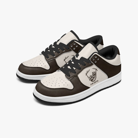 Angled three-quarter view of low-top sneakers in dark espresso brown and cream leather, featuring a raccoon relaxing in a hammock graphic with "SLOW CHAPTER", black laces, and a black inner lining.