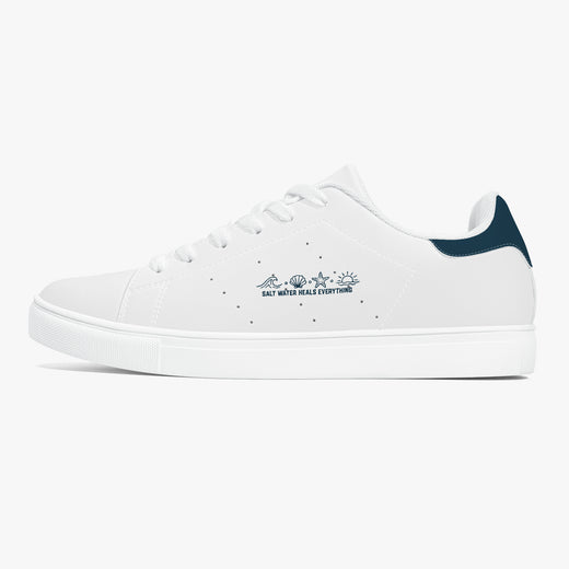 A white low-top sneaker with a dark navy heel tab and a navy graphic on the side reading 'SALT NEVER HIDE EVERYTHING' with small star and mountain illustrations. The shoe is shown in a clean profile view against a solid white background.