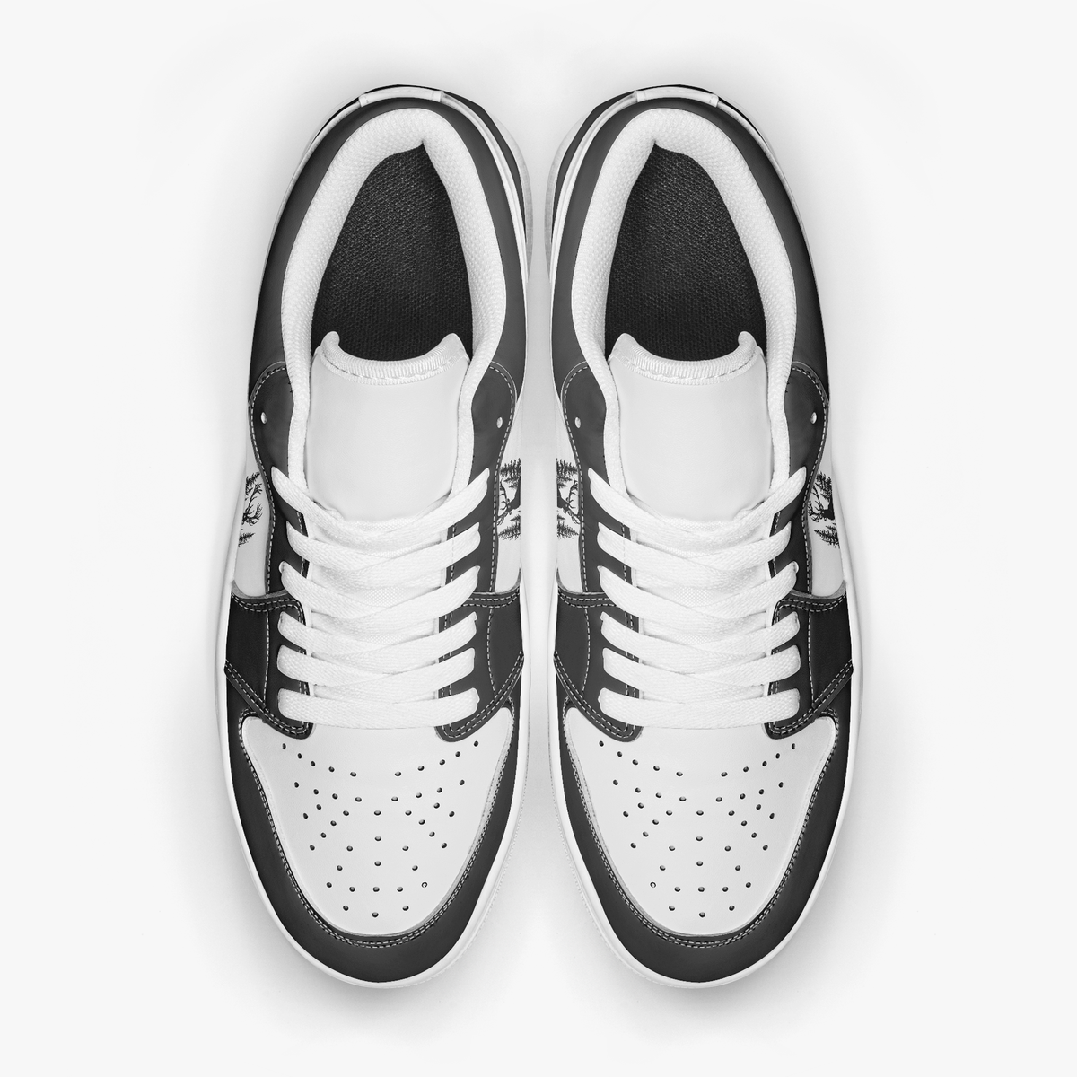 Overhead view of black and white sneakers showing clean white laces, white padded collar lining, and perforated white leather toe boxes.
