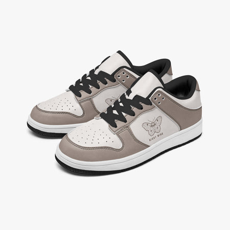 Angled three-quarter view of low-top sneakers in taupe grey-brown and off-white leather, featuring a moth illustration with "NIGHT WING", black laces, and a black inner lining.