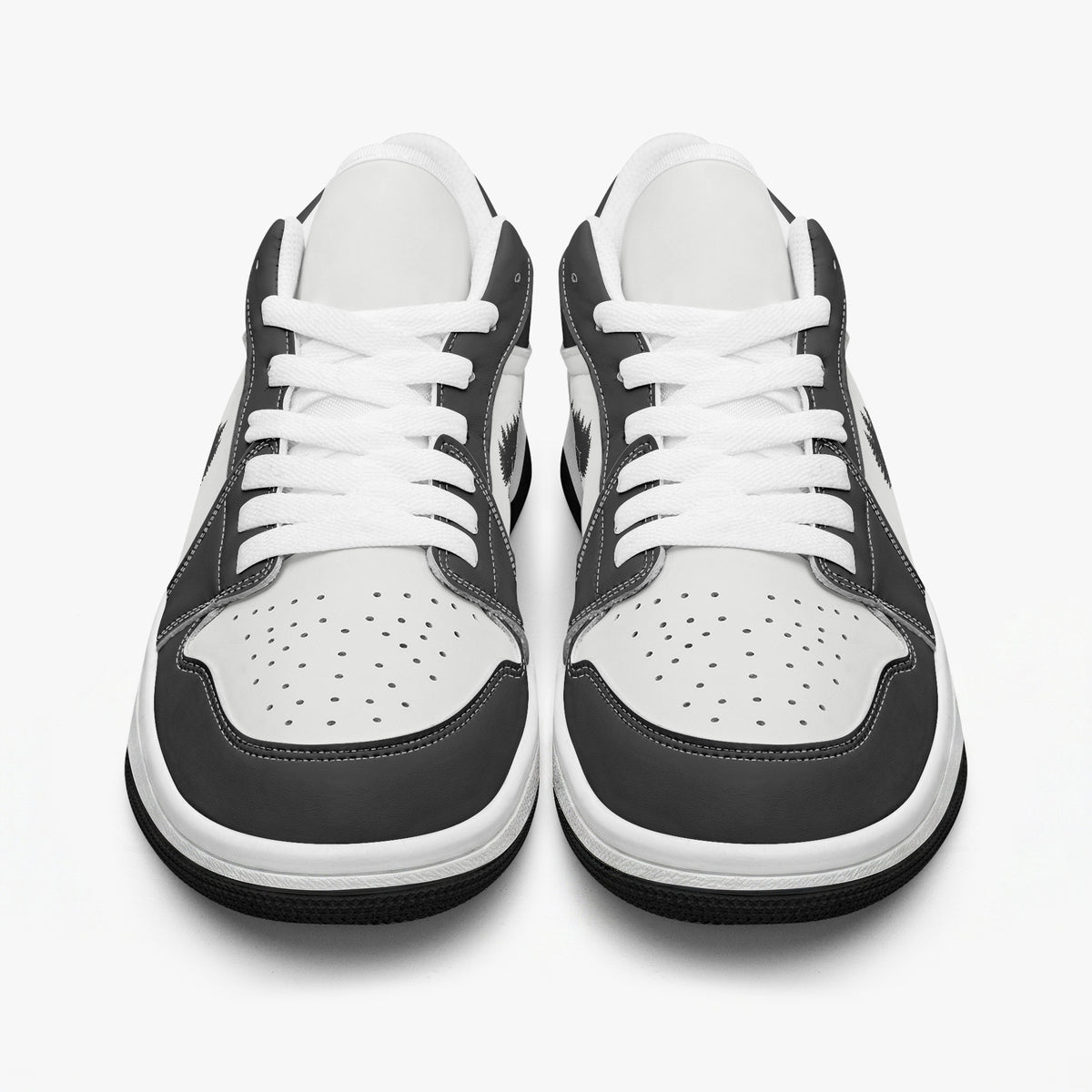 Front-facing eye-level view of black and white low-top sneakers displaying white laces, black eyestays, and perforated white toe boxes.