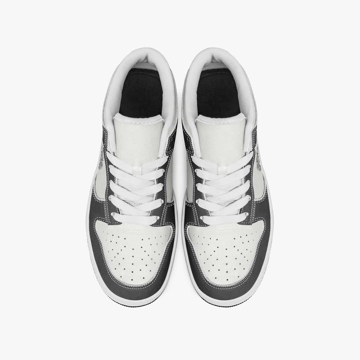 Overhead view of black and white sneakers showing clean white laces, white padded collar lining, and perforated white leather toe boxes.