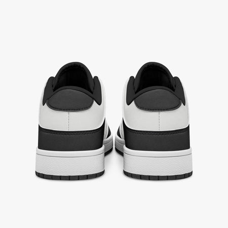 Rear view of black and white sneakers showing dark charcoal heel overlays, white leather collars, and black interior collar lining above white midsoles.