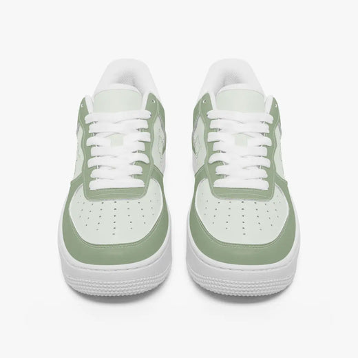 Front-facing top angle of low-top sneakers in sage green and light mint leather, displaying clean white laces, sage green eyestays, and perforated mint green toe boxes.