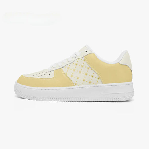 Outer side view of the left sneaker in pastel yellow and off-white with a small floral daisy print pattern facing left.