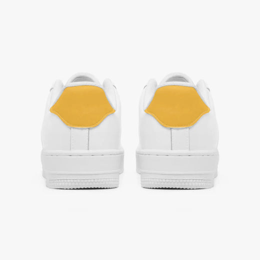 Rear view of white sneakers displaying mustard yellow heel tabs above thick white rubber outsoles.