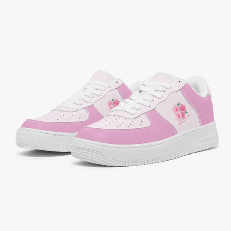 A pair of low-top sneakers in pastel pink and white, featuring embroidered pink cherry blossom flowers on the sides and white laces, set against a clean white background.