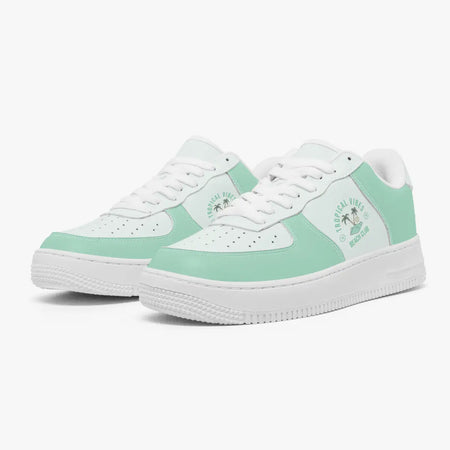 Angled three-quarter view of mint green and white sneakers featuring a "Tropical Vibes Beach Club" palm tree graphic printed on the side panel.