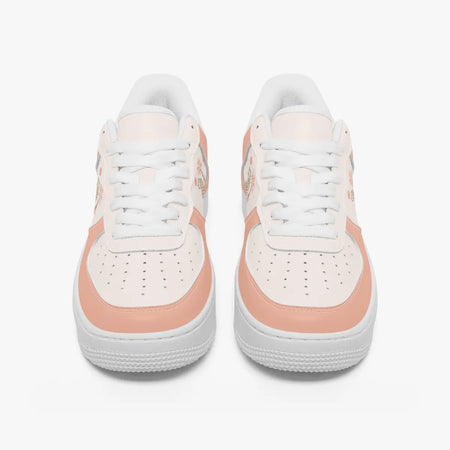 Front view of a pair of dusty peach and off-white low-top sneakers with white laces and perforated toe caps on a plain background.