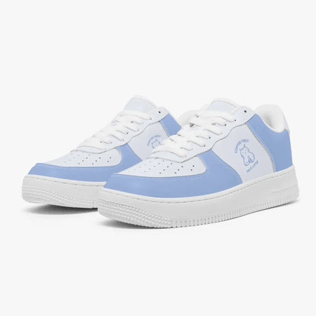 Angled three-quarter view of white and periwinkle blue sneakers featuring a minimalist line-art cat drinking coffee with "Coffee First, Talk Later" text.