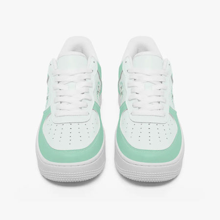 Front view of a pair of mint green and white low-top sneakers with white laces and perforated toe caps on a plain background.