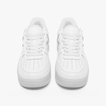 Front view of a pair of minimalist all-white low-top leather sneakers with white laces and perforated toe caps on a clean white background.