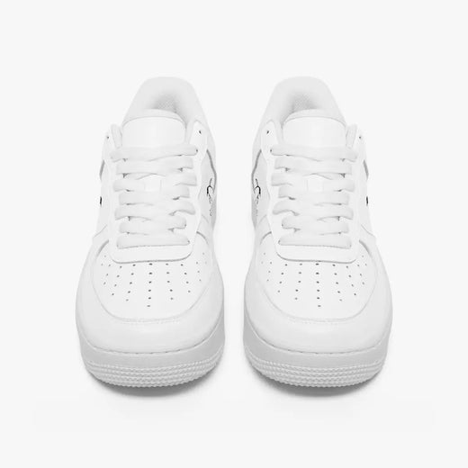 Front view of a pair of minimalist all-white low-top leather sneakers with white laces and perforated toe caps on a clean white background.