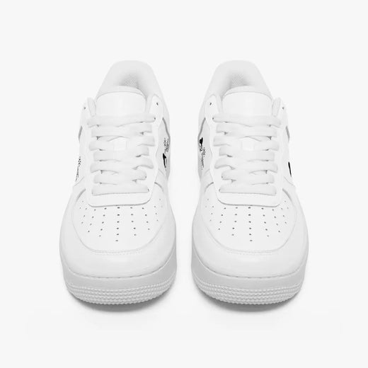 Front view of a pair of all-white low-top leather sneakers with white laces and perforated toe caps on a clean white background.