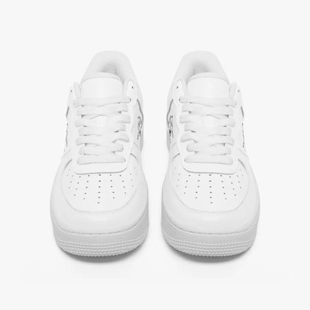 Front view of a pair of minimalist all-white low-top leather sneakers with white laces and perforated toe caps on an isolated white background.