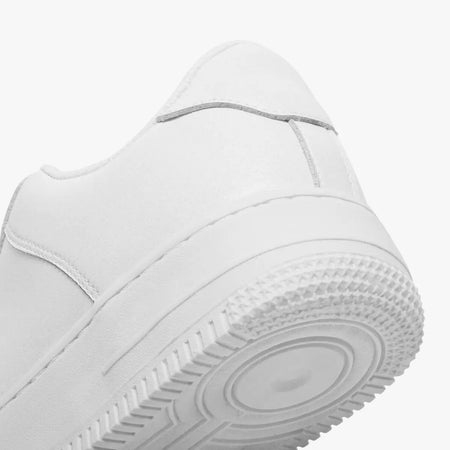White sneaker with a focus on sole and tread pattern on a light gray background