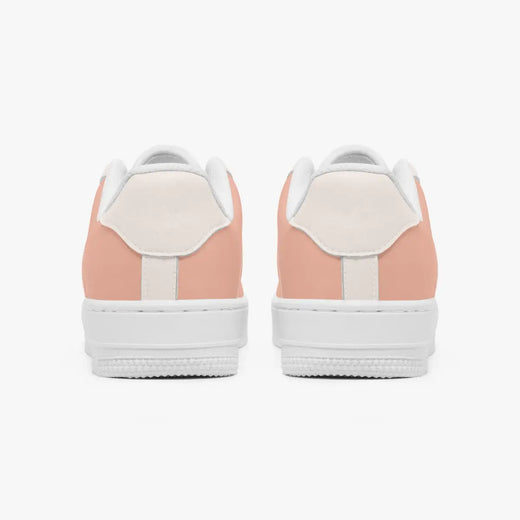 Rear view of a pair of dusty rose and cream low-top sneakers showing the padded heel counters and flat white rubber soles.