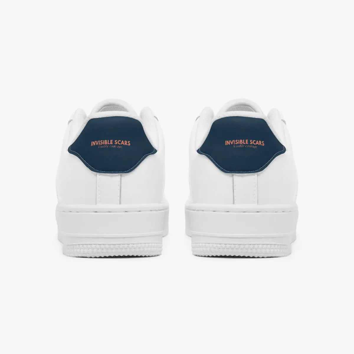 A pair of white low-top sneakers shown from the back, featuring a dark navy blue heel tab with the words 'INVISIBLE SCARS' in orange text.
