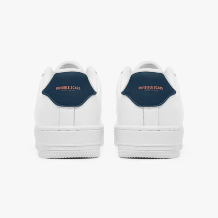 A pair of white low-top sneakers shown from the back, featuring a dark navy blue heel tab with the words 'INVISIBLE SCARS' in orange text.