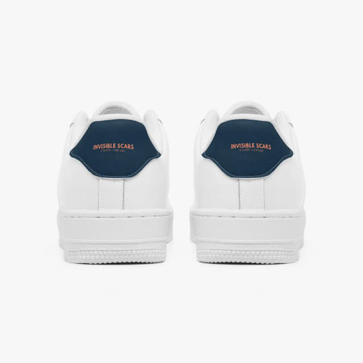 A pair of white low-top sneakers shown from the back, featuring a dark navy blue heel tab with the words 'INVISIBLE SCARS' in orange text.
