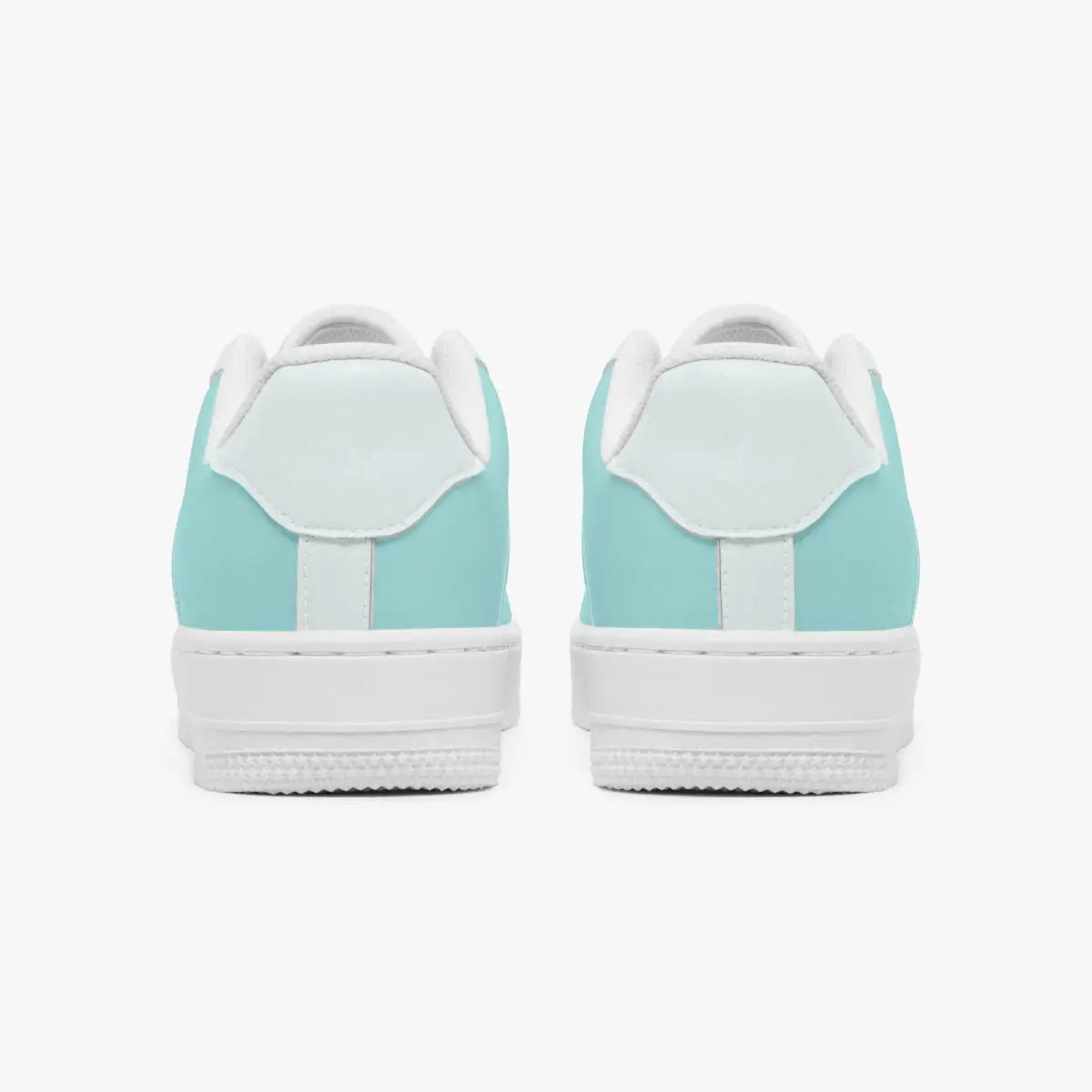 Rear view of mint green and white leather sneakers showing the padded heel counters and textured white rubber outsoles.