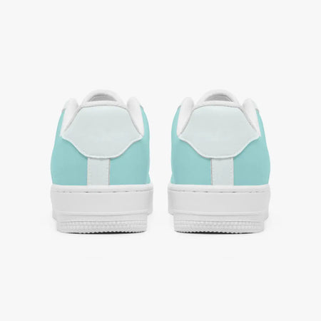 Rear view of mint green and white leather sneakers showing the padded heel counters and textured white rubber outsoles.