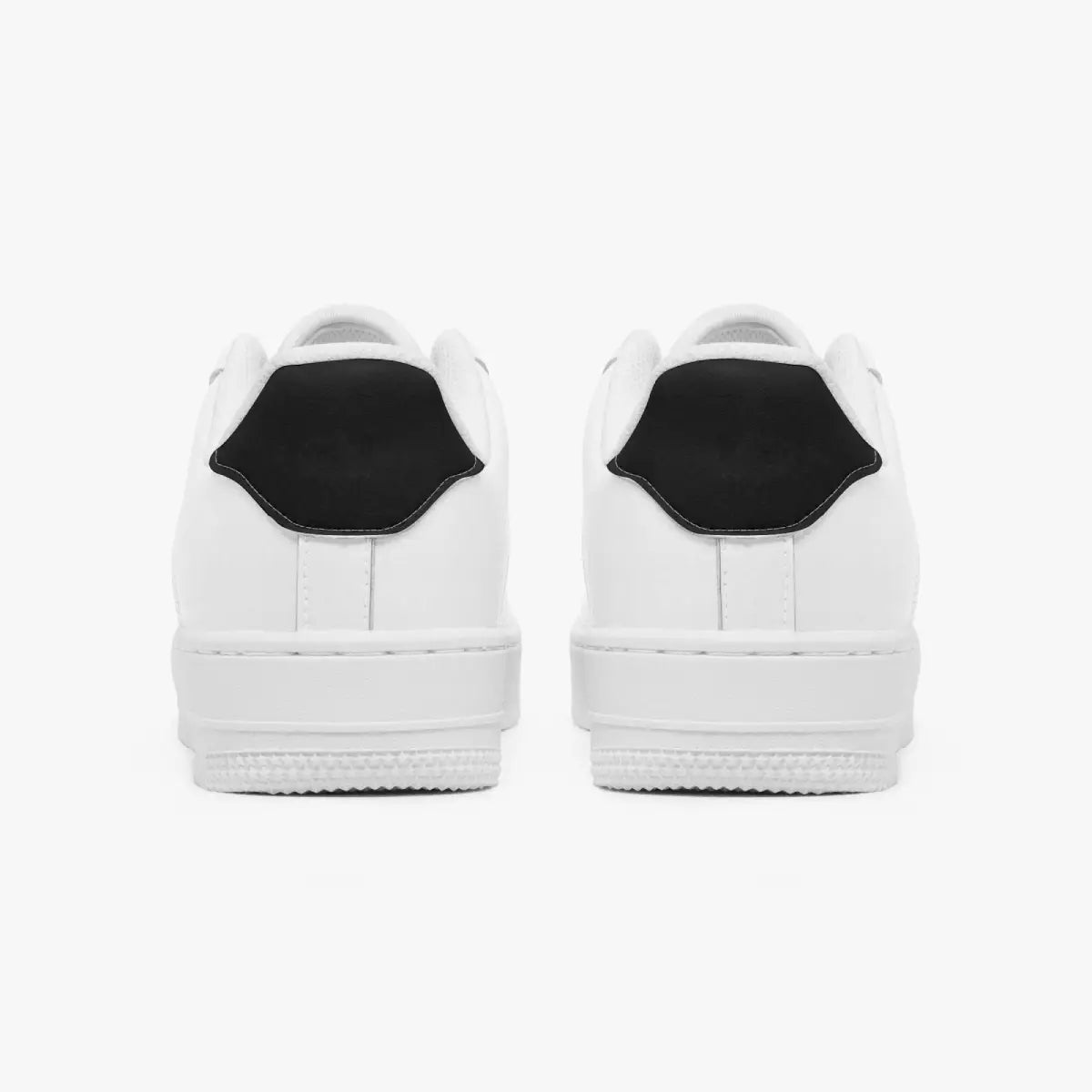 Rear view of white low-top sneakers showing solid black heel tabs and flat white rubber outsoles.