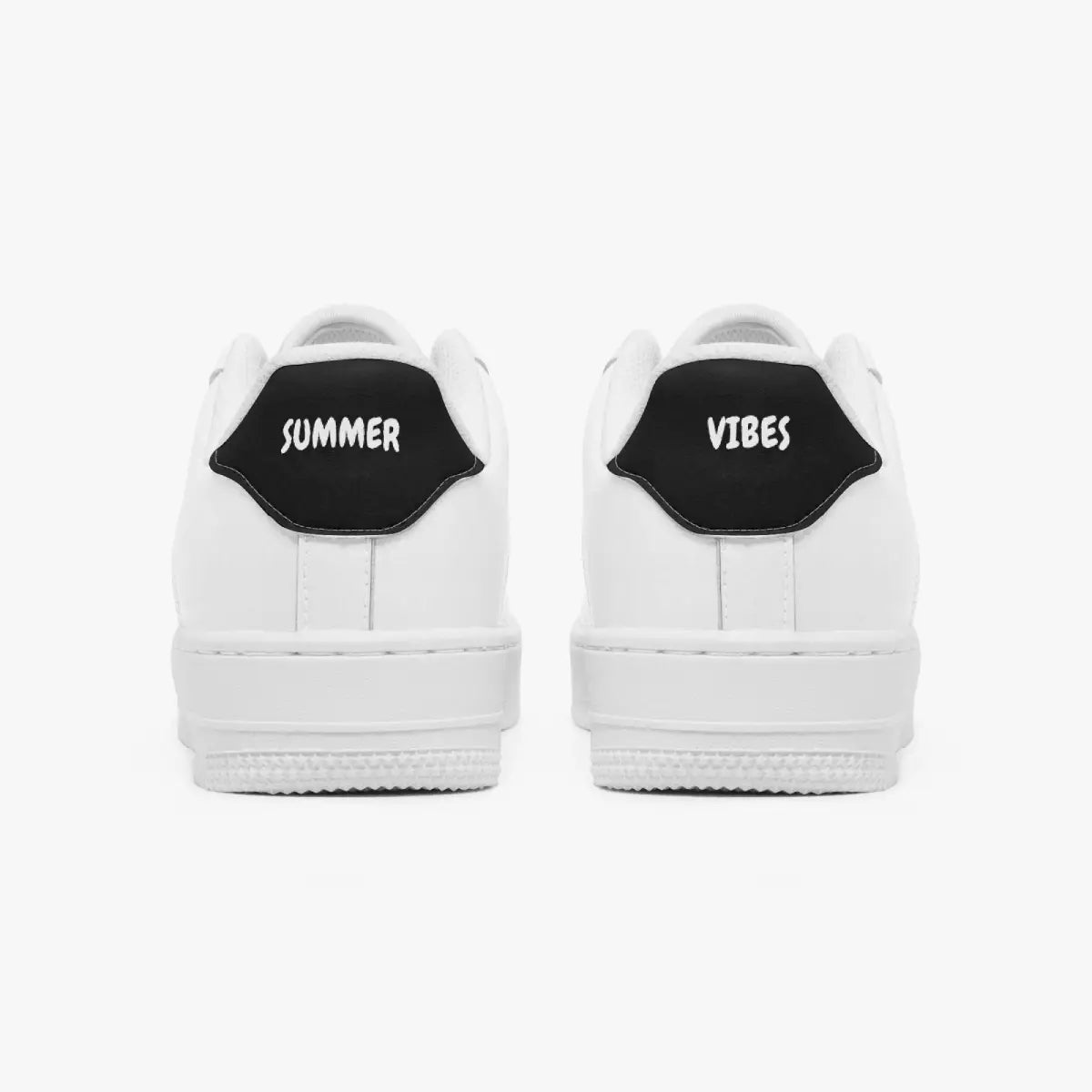 Rear view of white low-top sneakers showing black heel tabs with "SUMMER VIBES" text and solid white rubber soles.