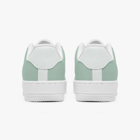A pair of low-top sneakers shown from the back, featuring a mint green leather upper and a white rubber sole, set against a plain light gray background.