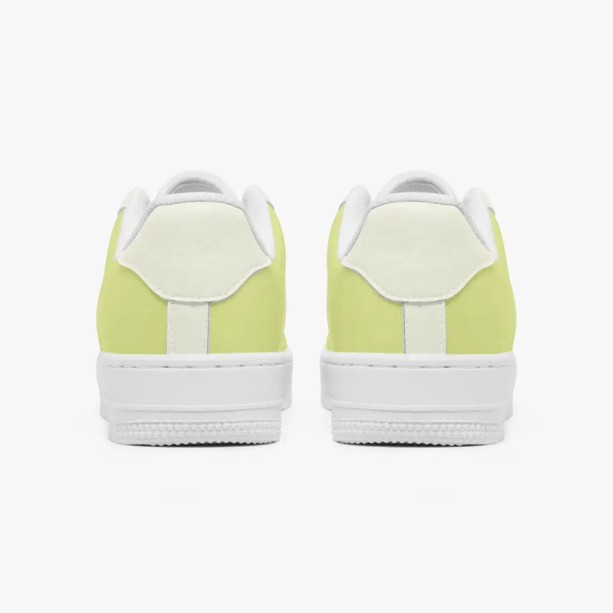 Rear view of a pair of pastel yellow and off-white sneakers showing the padded heel counters and flat white rubber soles.
