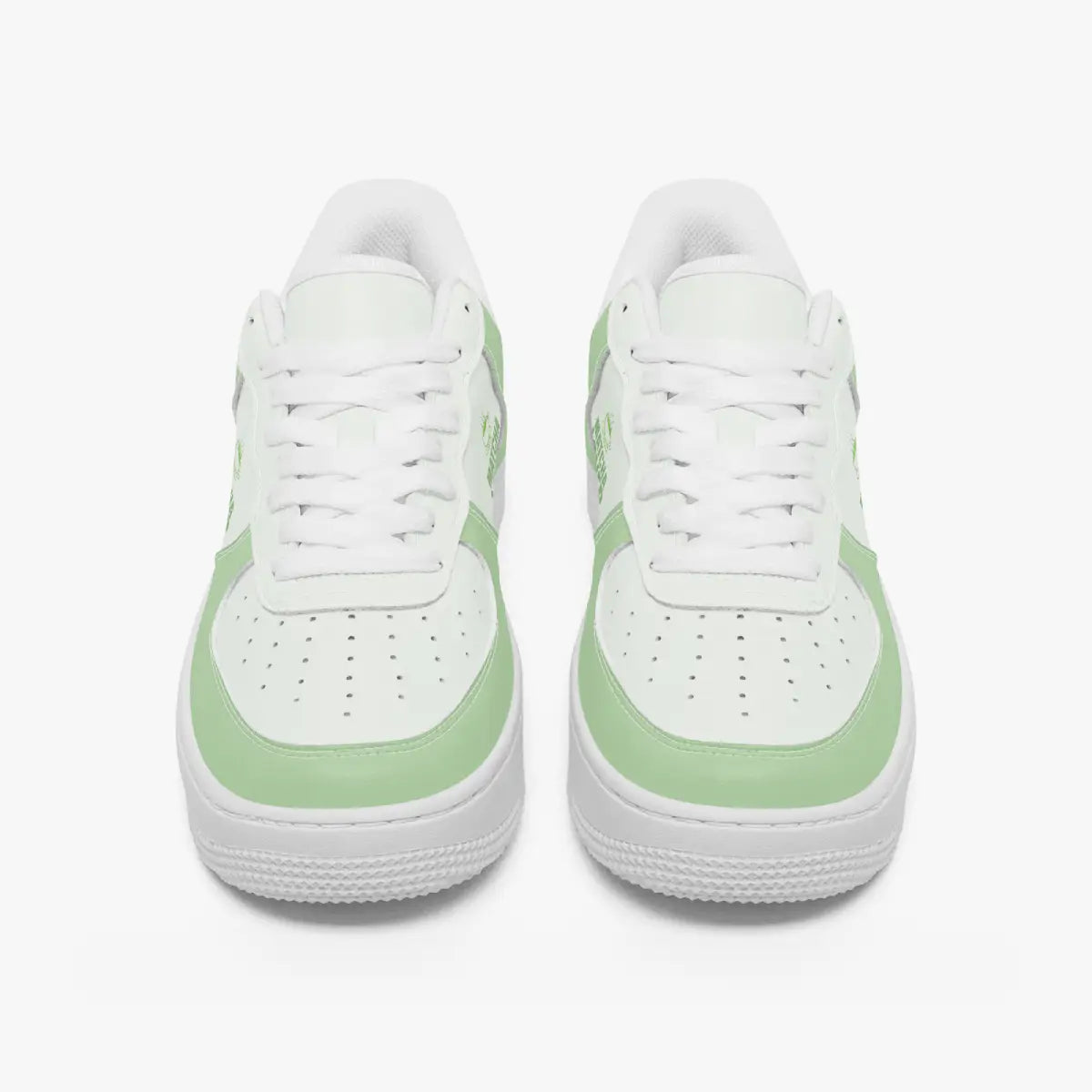 Front view of a pair of matcha green and white low-top leather sneakers with white laces and perforated toe caps.