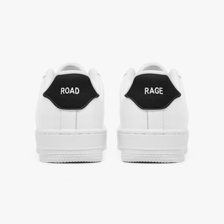 Rear view of white low-top sneakers showing contrasting black heel tabs labeled "ROAD" and "RAGE" above flat white rubber soles.