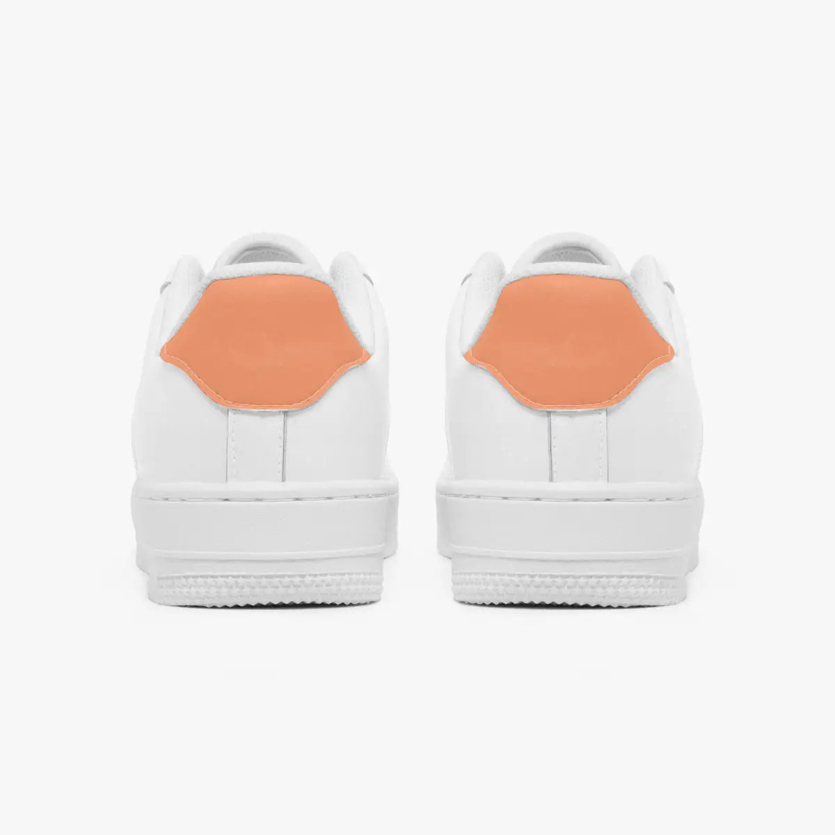 Rear view of white sneakers showing contrasting dusty coral heel tabs above flat white rubber soles.