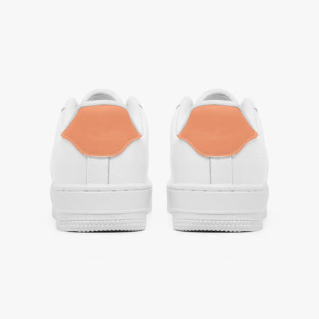 Rear view of white sneakers showing contrasting dusty coral heel tabs above flat white rubber soles.