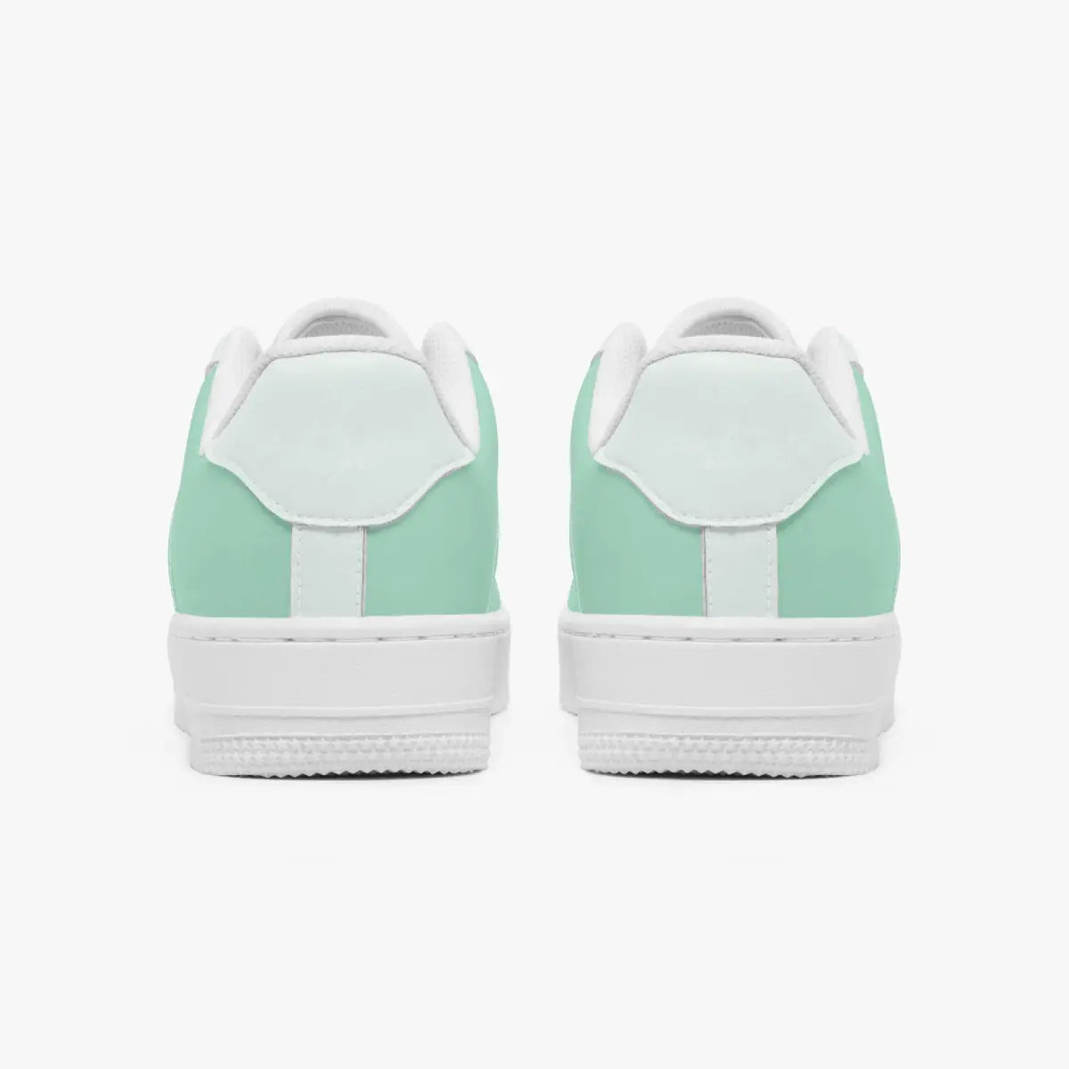 Rear view of mint green and white leather sneakers showing the padded heel counters and flat white rubber soles.