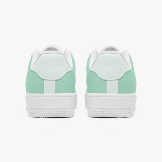 Rear view of mint green and white leather sneakers showing the padded heel counters and flat white rubber soles.