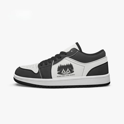 Side profile view of the right low-top sneaker in charcoal black and white leather, featuring a camping tents graphic with "WARM FIRES, COOL NIGHTS", black laces, and a black inner lining facing right.