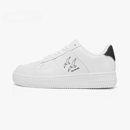 Side profile view of the left sneaker in white leather, highlighting the "WILD AND FREE" soaring birds illustration, black heel tab accent, white laces, and flat white cupsole facing right.