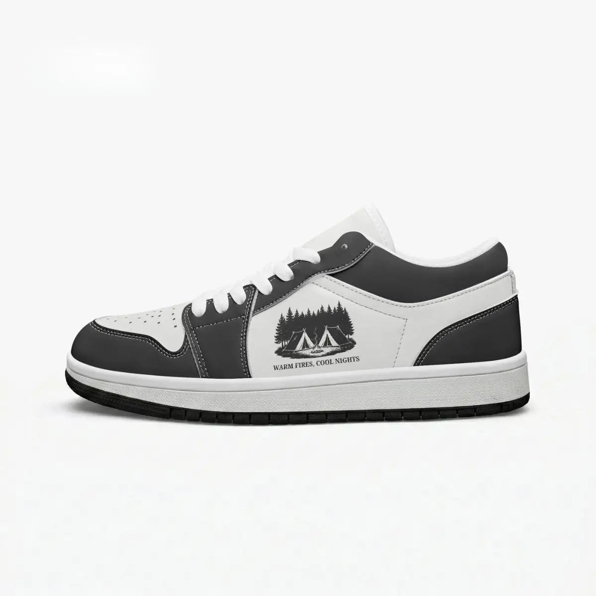 Side profile view of the right low-top sneaker in charcoal black and white leather, featuring a camp tents and pine forest graphic with "WARM FIRES, COOL NIGHTS", white laces, and a flat rubber sole facing right.